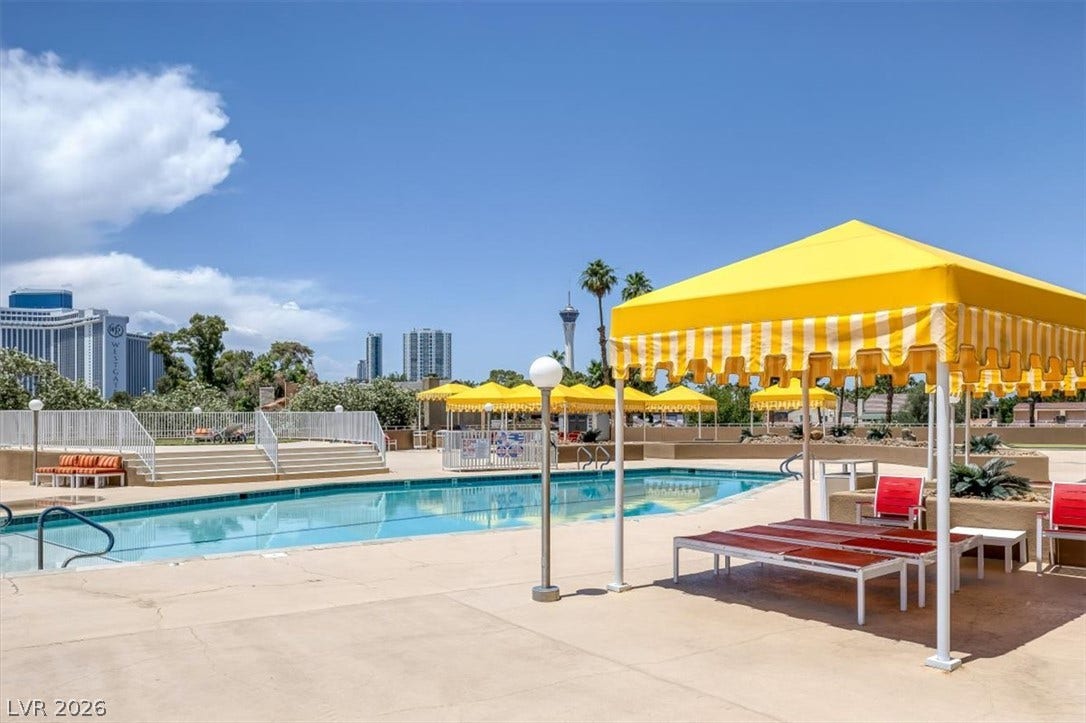 3111 Bel Air Drive, #7D, Las Vegas, NV 89109 An inviting swimming pool area sits surrounded by spacious concrete decking under open desert skies.