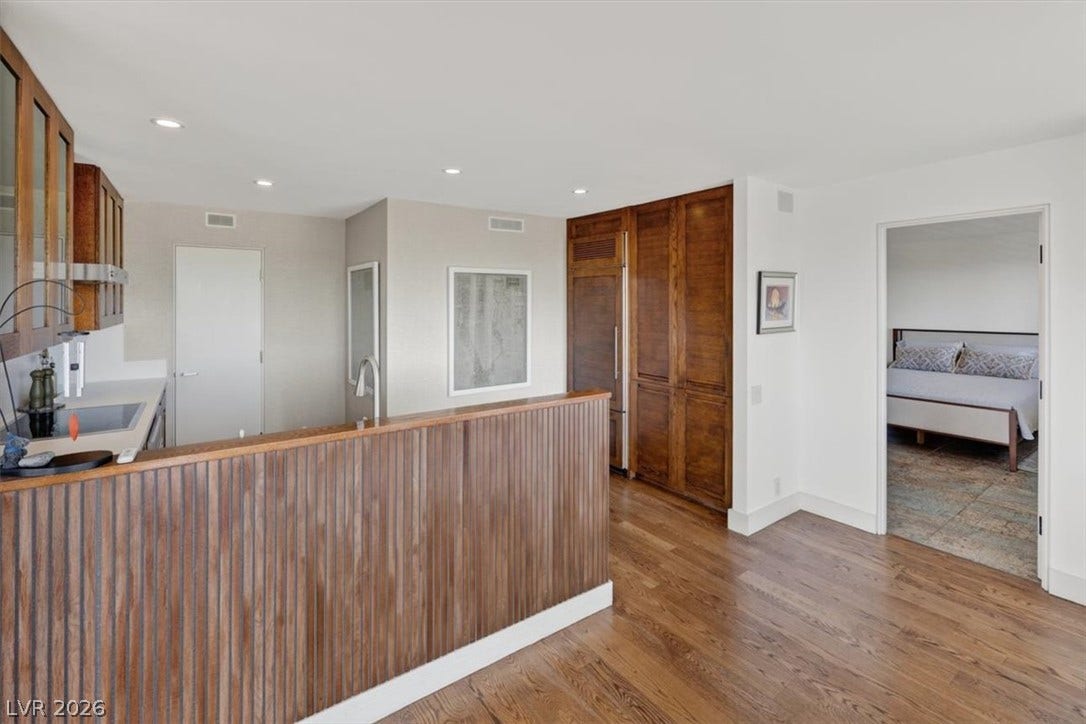 3111 Bel Air Drive, #7D, Las Vegas, NV 89109 Rich hardwood flooring complements custom wood cabinetry in this open kitchen layout.