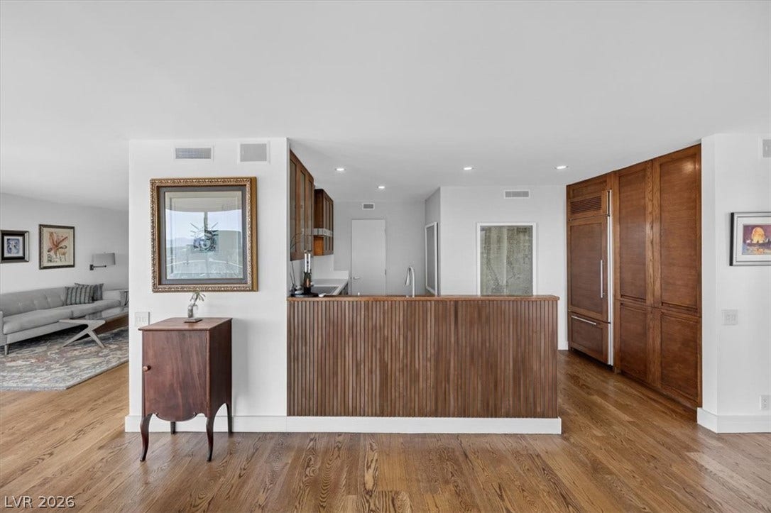 3111 Bel Air Drive, #7D, Las Vegas, NV 89109 Rich wood flooring runs throughout the seamless layout connecting the living spaces and kitchen.