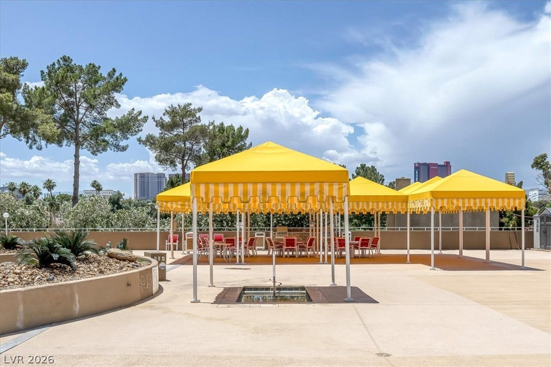 3111 Bel Air Drive, #7D, Las Vegas, NV 89109 Shaded canopies shelter an outdoor patio area with city views under open skies.