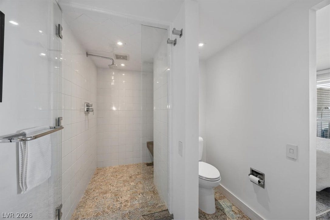 3111 Bel Air Drive, #7D, Las Vegas, NV 89109 An inviting walk-in shower features classic wall tiling and stone-patterned flooring.