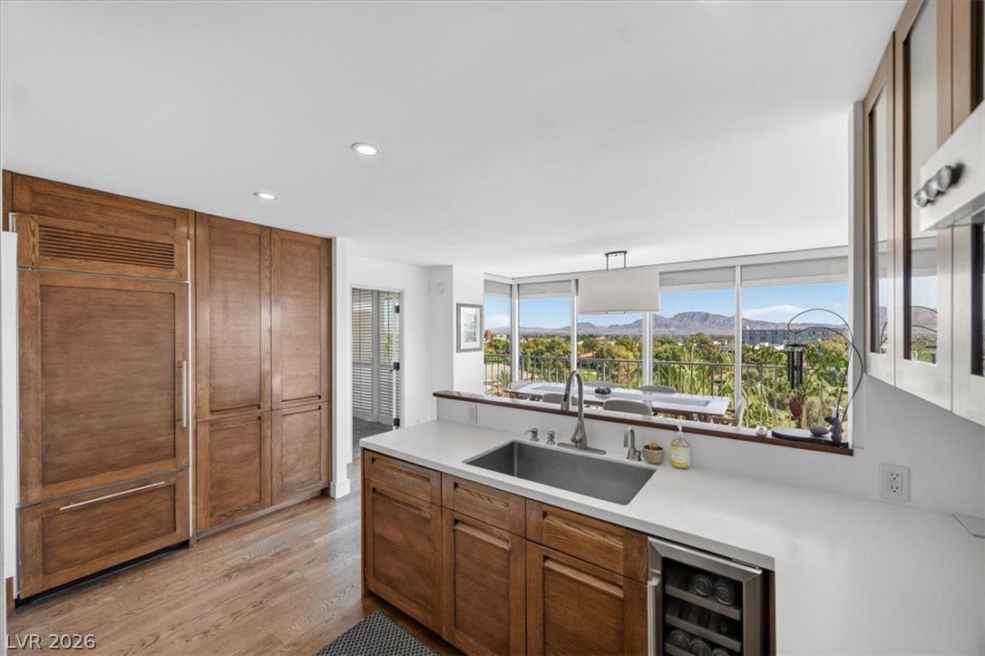 3111 Bel Air Drive, #7D, Las Vegas, NV 89109 Rich wood cabinetry and clean quartz countertops frame breathtaking mountain views from this kitchen.