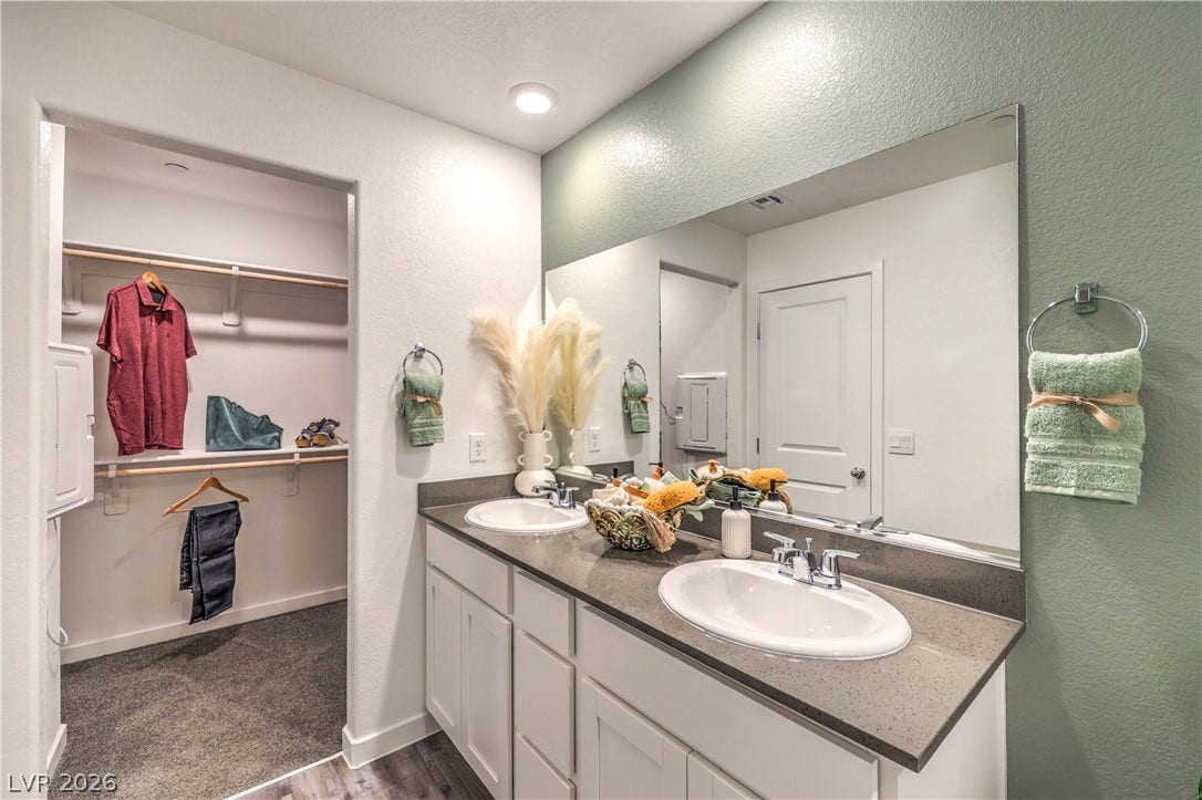 923 Black Heron Street, Henderson, NV 89011 Double vanities with stone counters flank a spacious walk-in closet.