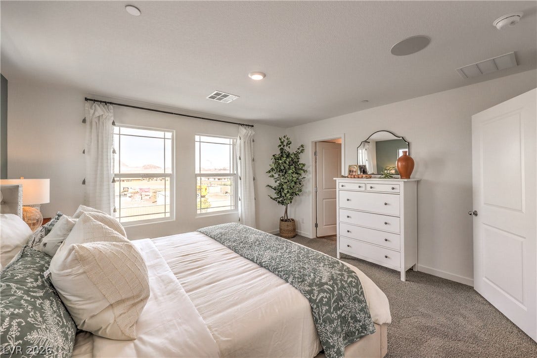 923 Black Heron Street, Henderson, NV 89011 Sunlight streams through large windows into this spacious bedroom featuring clean lines and textured carpeting.