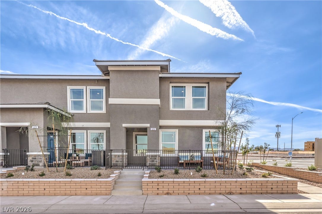 923 Black Heron Street, Henderson, NV 89011 A modern multi-level exterior stands behind low brick retaining walls and minimalist desert landscaping.