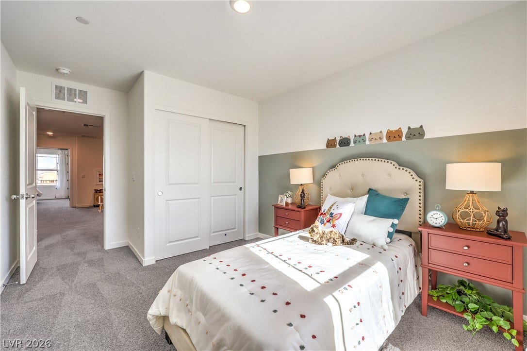 923 Black Heron Street, Henderson, NV 89011 A spacious bedroom features soft carpeting, neutral walls, and a large closet with sliding doors.