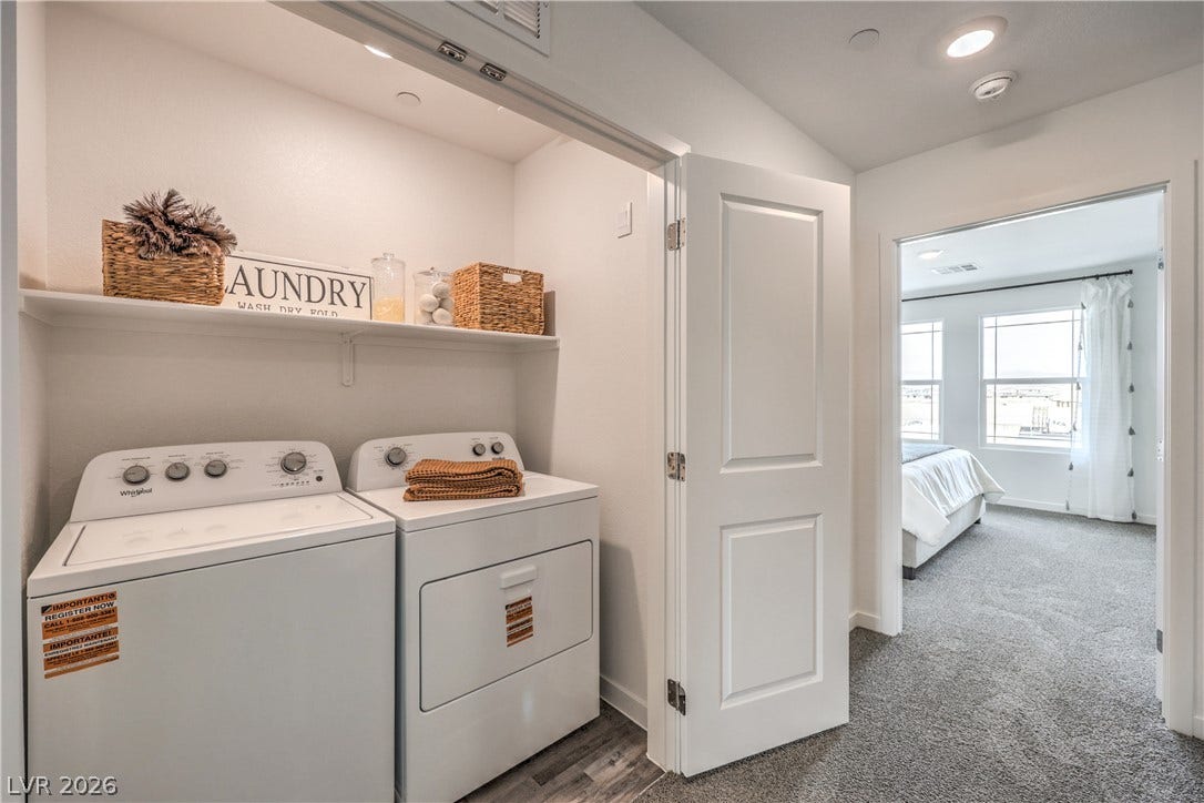 923 Black Heron Street, Henderson, NV 89011 An organized laundry closet features built-in shelving and transitions smoothly into a carpeted hallway.