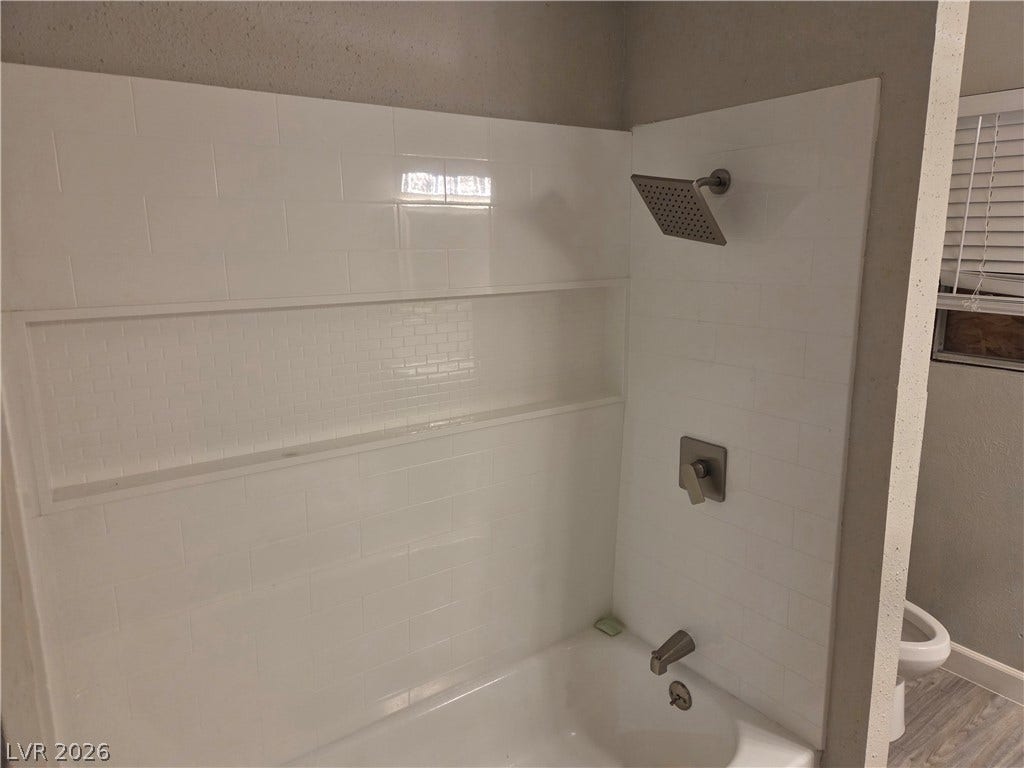4364 Calimesa Street, Las Vegas, NV 89115 Crisp subway tile surrounds this bathtub installation, featuring a built-in storage niche and modern fixtures.