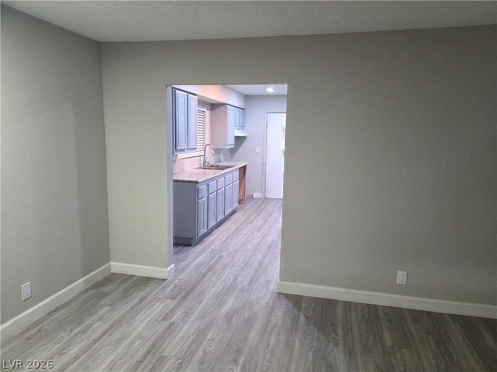 4364 Calimesa Street, Las Vegas, NV 89115 An open doorway connects the main living space to a functional kitchen with stone counters.