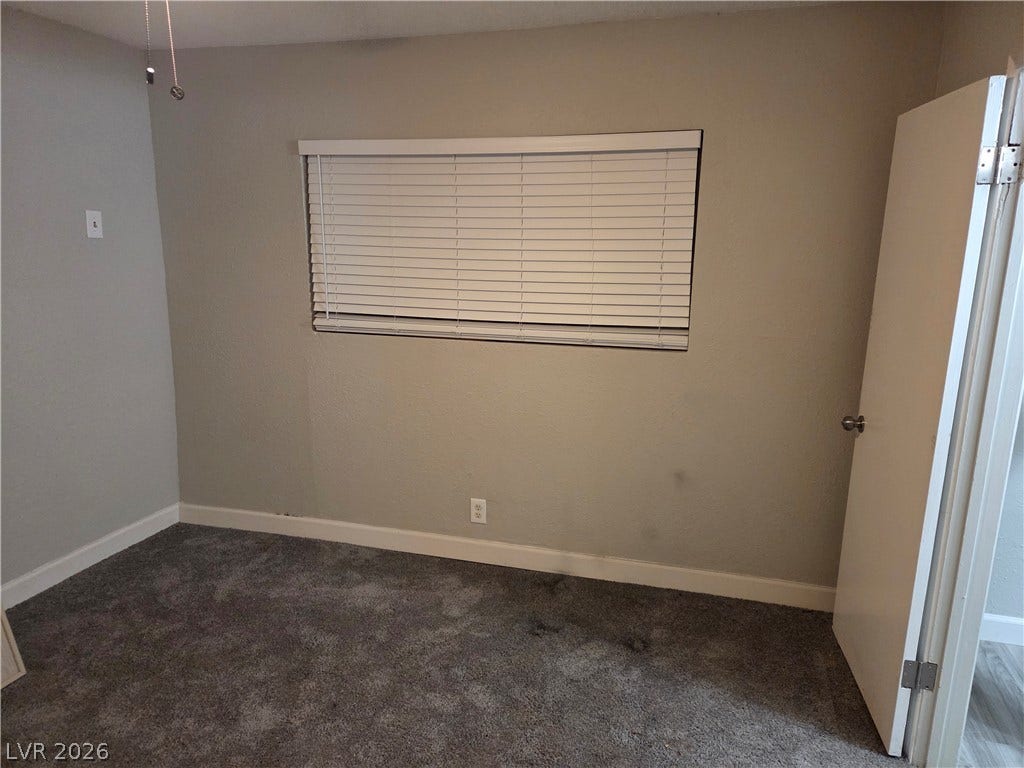 4364 Calimesa Street, Las Vegas, NV 89115 Plush carpeting and a wide window with horizontal blinds anchor this cozy bedroom space.