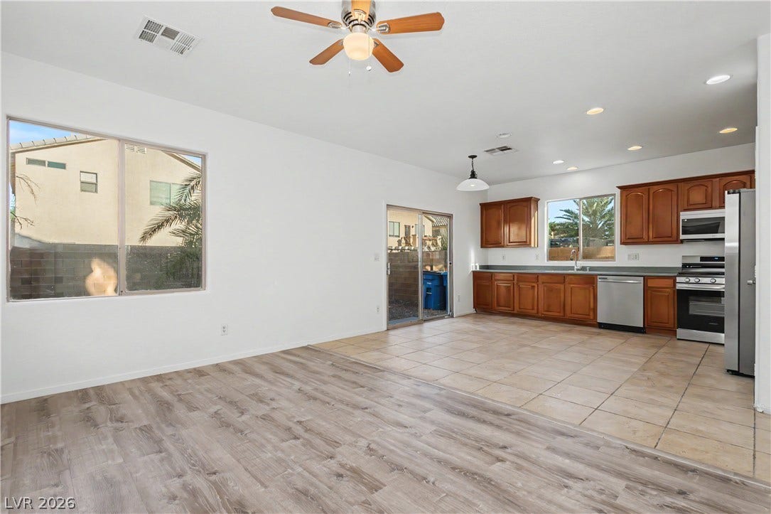 An open floorplan seamlessly connects the bright living area with the tile-floored kitchen.