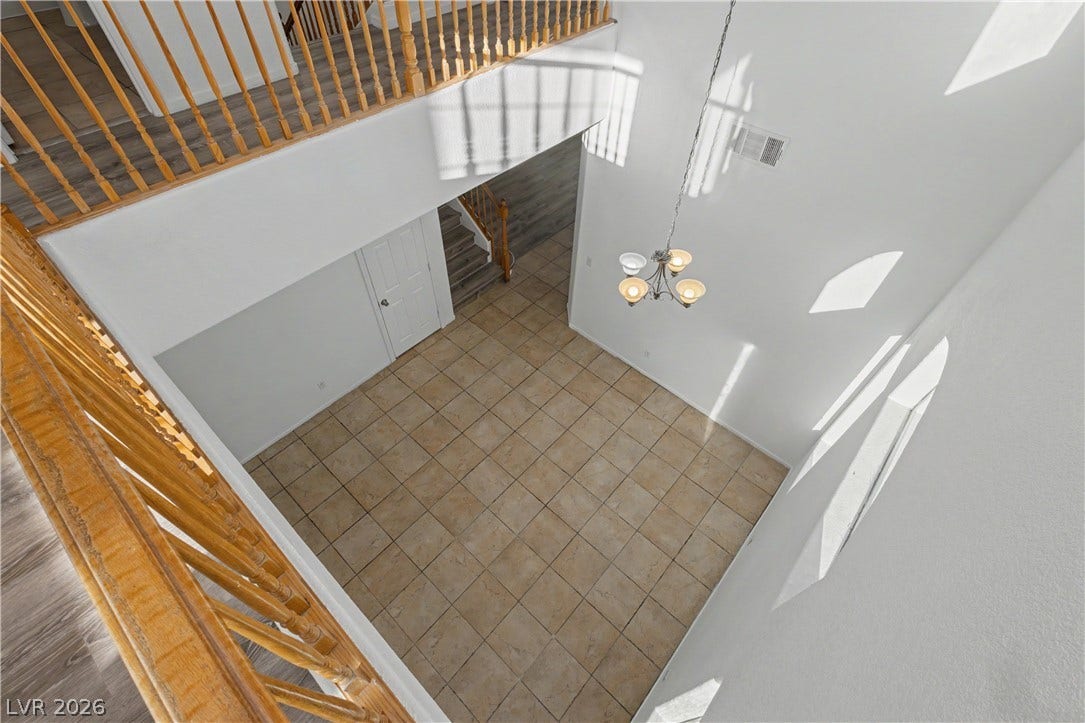 Soaring ceilings and warm tile flooring create an airy, welcoming entryway.