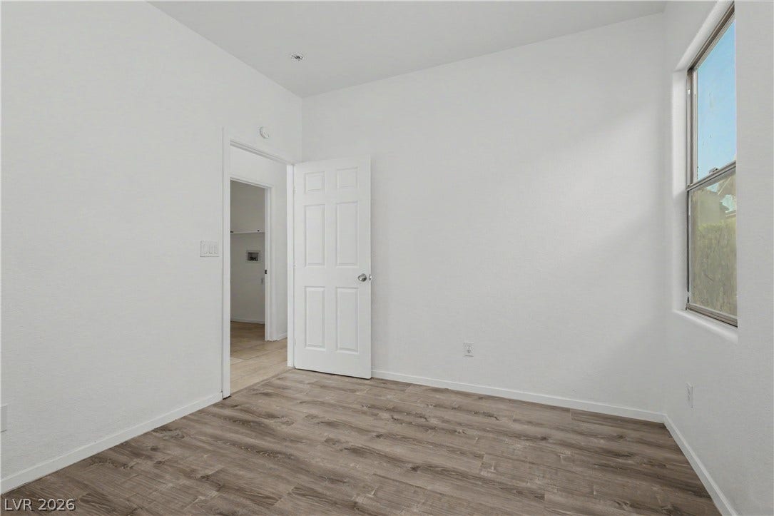 Clean lines and wood-look flooring define this versatile secondary bedroom space.