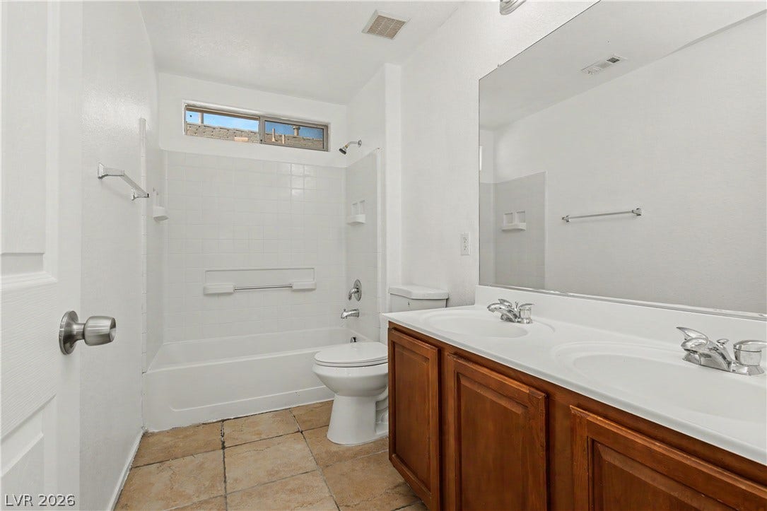 A spacious double vanity and tile flooring highlight this functional bathroom design.