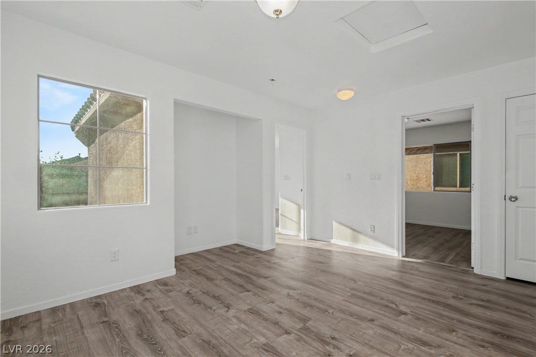 Gleaming wood-look floors anchor this versatile room illuminated by abundant natural light.
