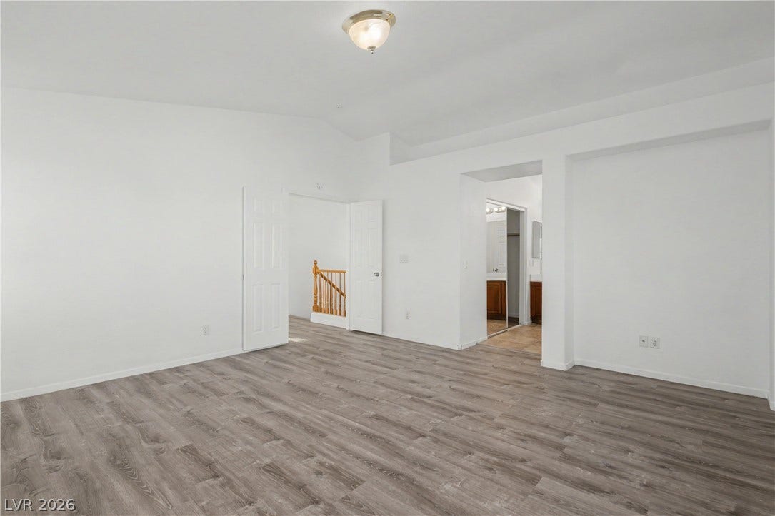 Gleaming wood-look floors and vaulted ceilings elevate this spacious bedroom suite.