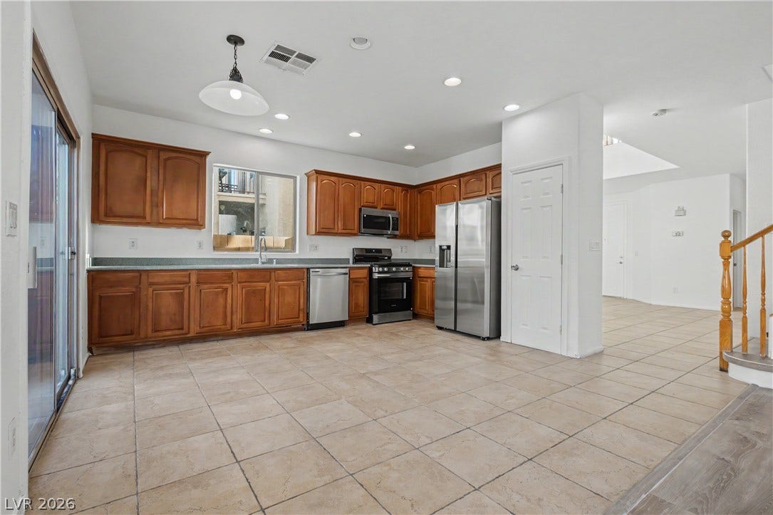 Rich wood cabinetry paired with durable tile flooring shapes this functional culinary space.
