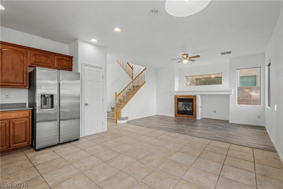 Tile and wood-style flooring transition seamlessly through this versatile, open-concept living space.