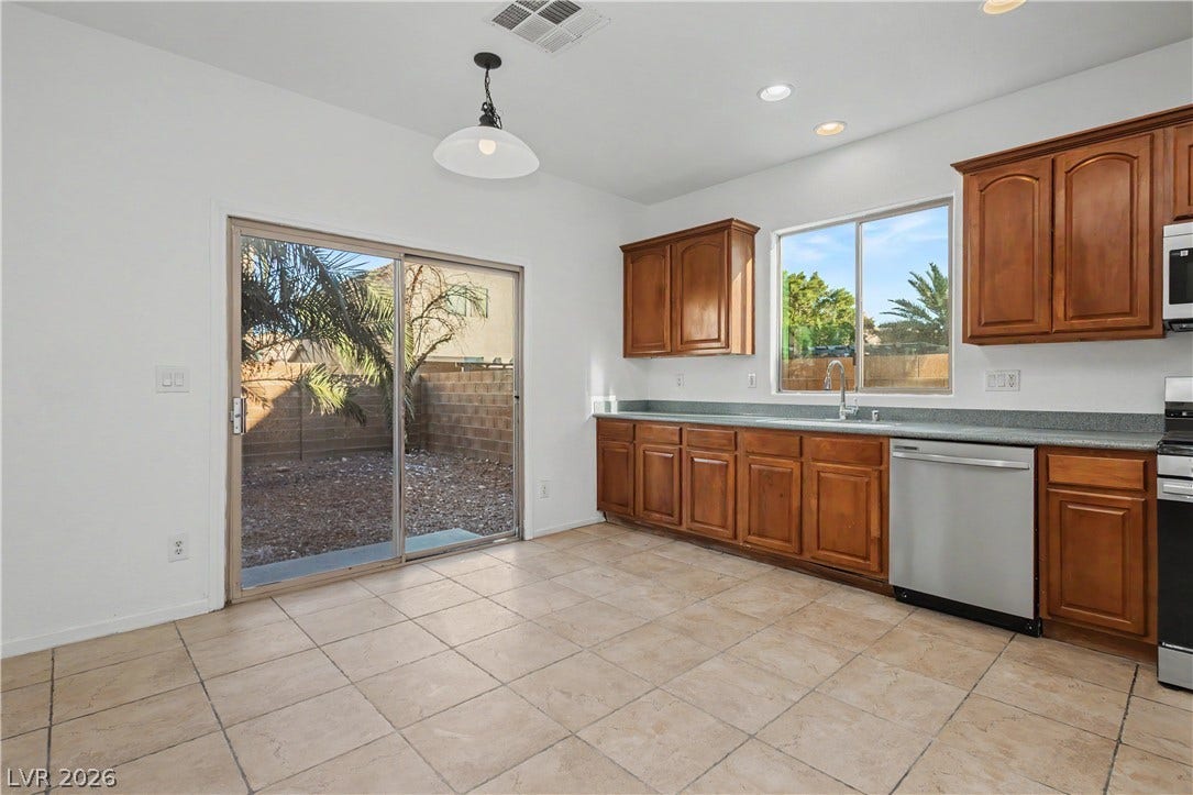 Sliding glass doors open directly to the backyard from this spacious tile-floored kitchen.