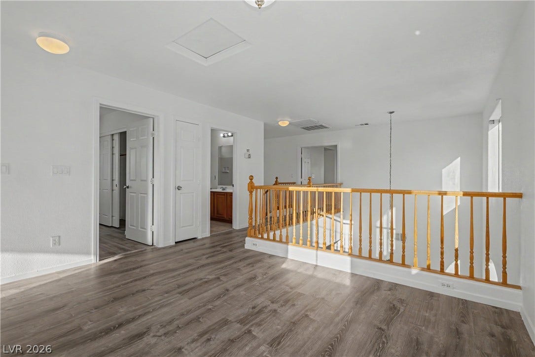 An open upper level landing features rich wood-look flooring and a classic balustrade.