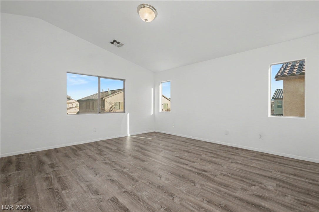 Vaulted ceilings and wide-plank wood-style flooring elevate this versatile upper-level space.