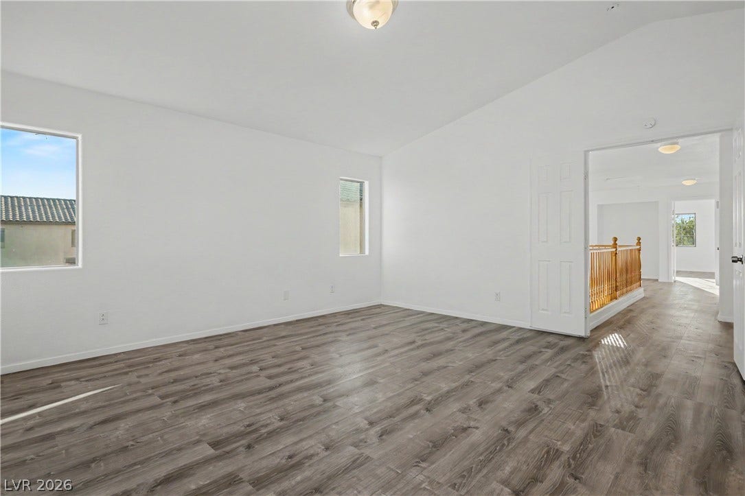 Gleaming wood-look floors pair with crisp white walls in this versatile upstairs living space.