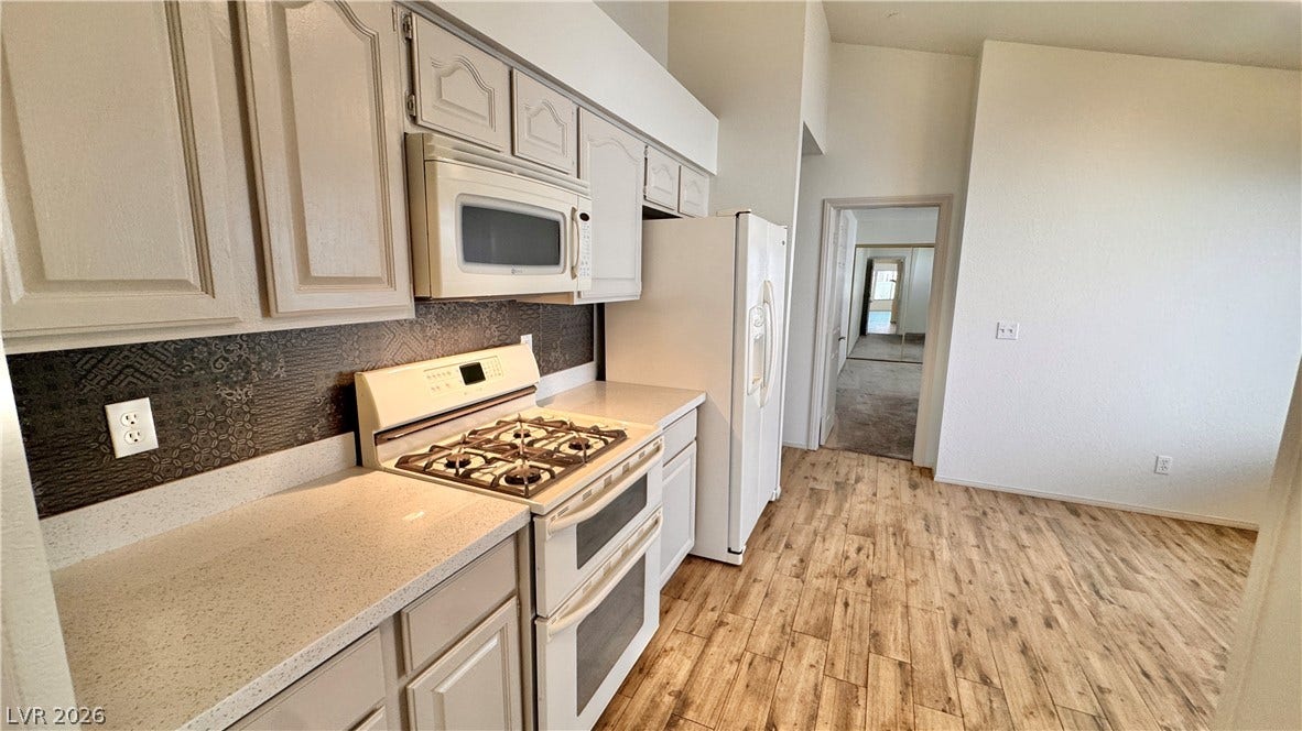5236 Crooked River Circle, Las Vegas, NV 89149 Gleaming stone counters and warm wood floors define this bright kitchen space.