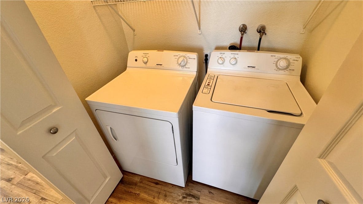 5236 Crooked River Circle, Las Vegas, NV 89149 A dedicated laundry closet features wood-look flooring and built-in shelving above the appliances.