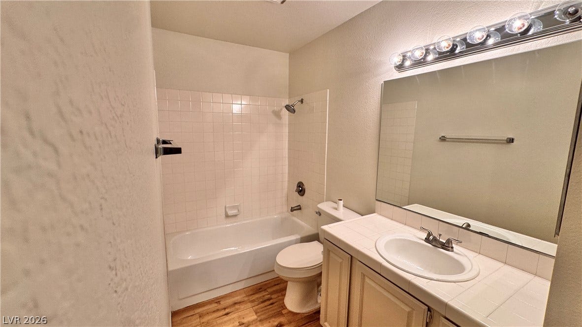 5236 Crooked River Circle, Las Vegas, NV 89149 A classic bathtub and tile vanity setup is complemented by warm wood flooring.