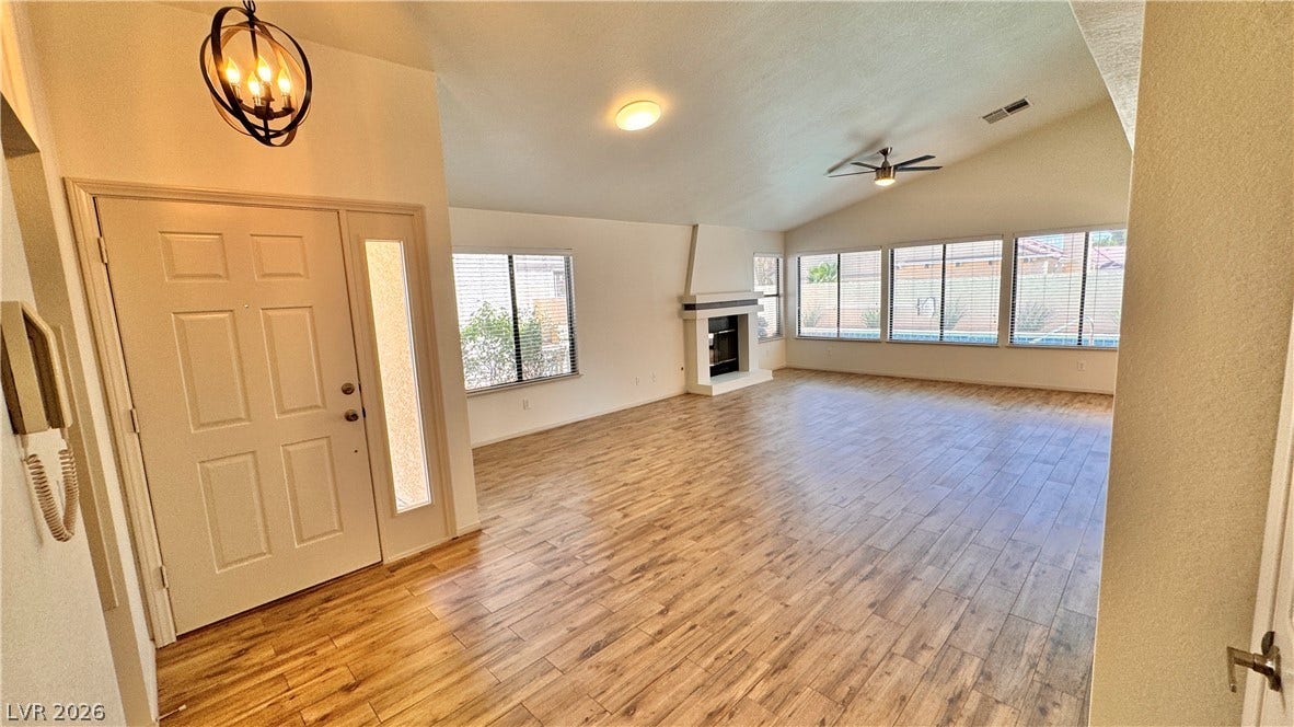 5236 Crooked River Circle, Las Vegas, NV 89149 Hardwood floors and a vaulted ceiling elevate this open main living space with backyard views.
