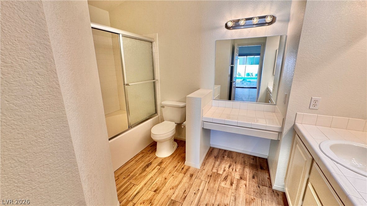 5236 Crooked River Circle, Las Vegas, NV 89149 Rich wood-look flooring complements the clean tiled vanity and matching tub surround.