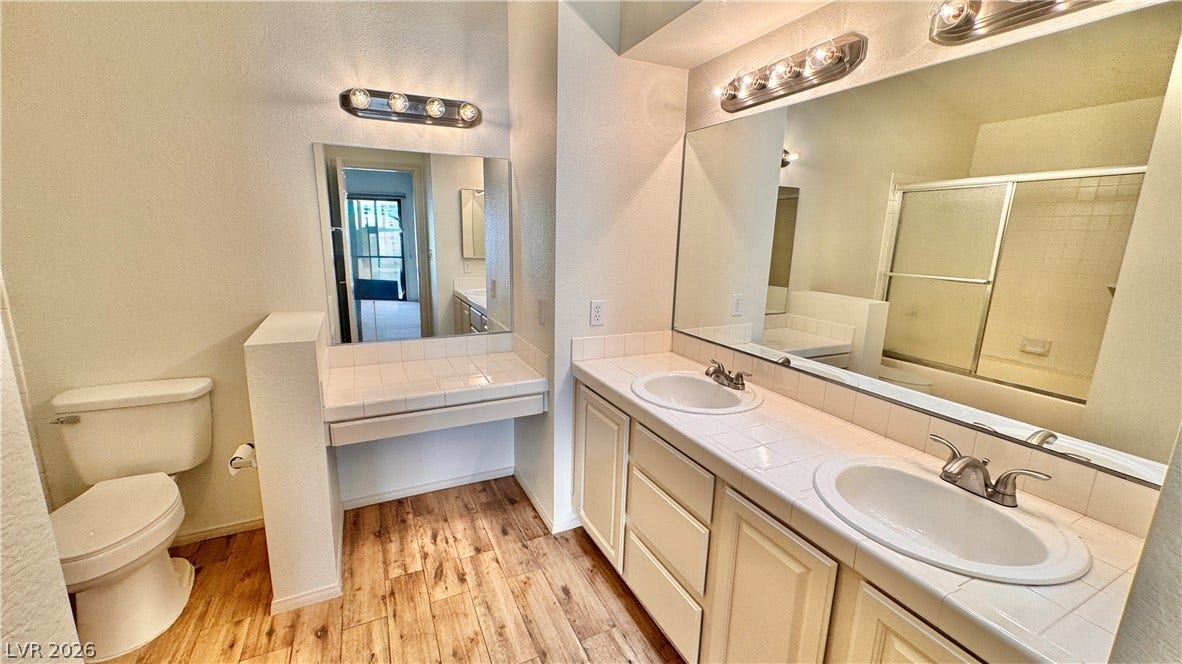 5236 Crooked River Circle, Las Vegas, NV 89149 Ample counter space and wood-look flooring define this functional bathroom layout.