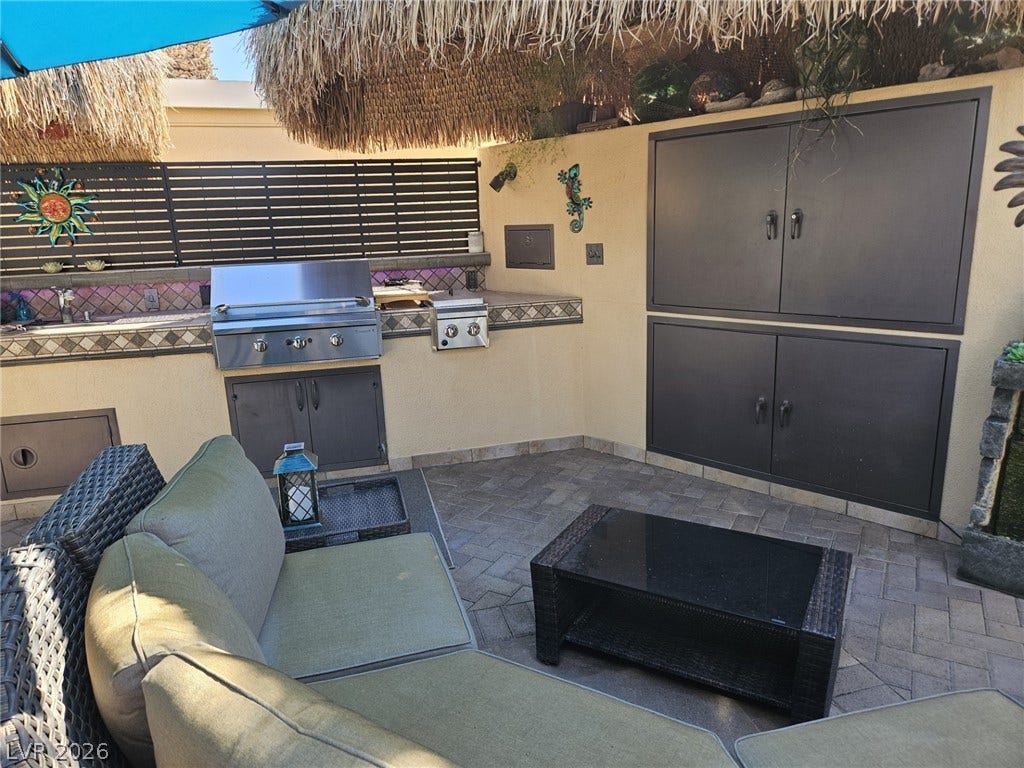8175 Arville Street, #305, Las Vegas, NV 89139 An integrated outdoor grill and built-in storage cabinets elevate this paved patio space.