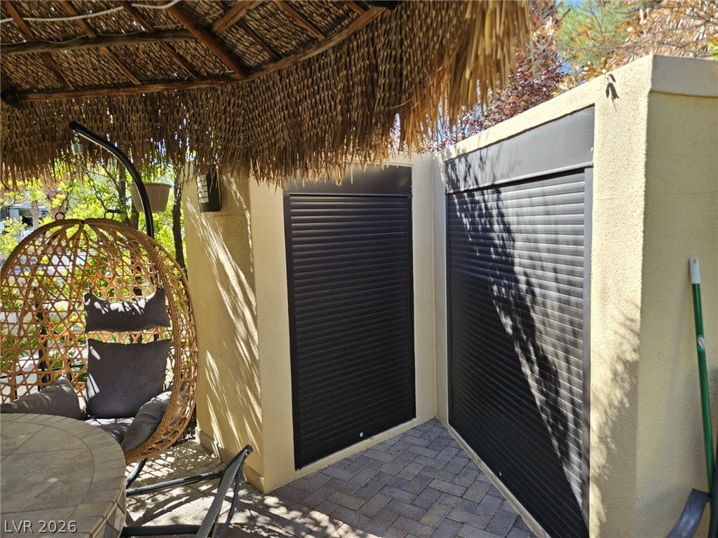 8175 Arville Street, #305, Las Vegas, NV 89139 A shaded outdoor patio area showcases textured stucco walls and durable paver flooring.