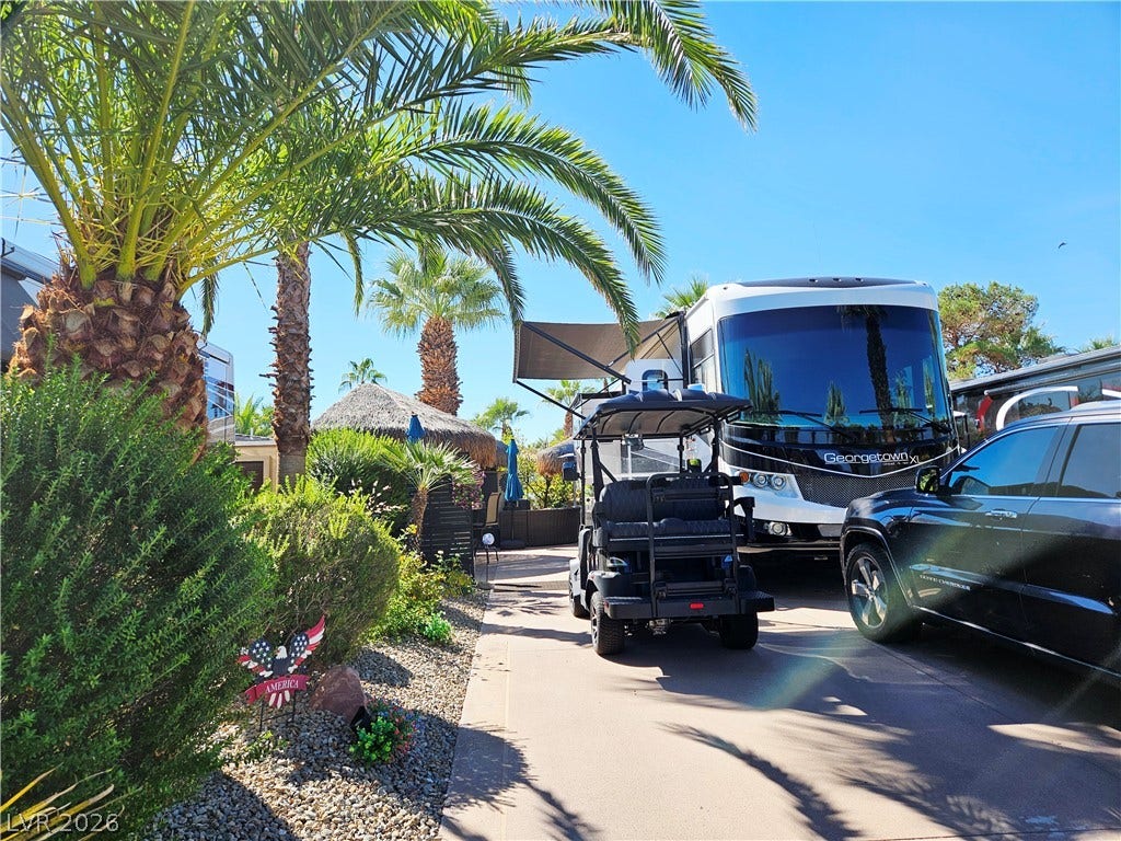 8175 Arville Street, #305, Las Vegas, NV 89139 Mature palm trees and neat landscaping frame a paved driveway with ample parking space.