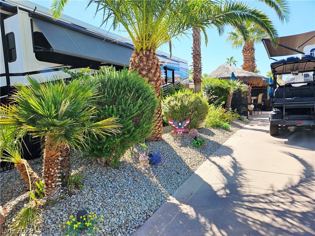 8175 Arville Street, #305, Las Vegas, NV 89139 Lush tropical landscaping and neat gravel beds frame a paved driveway with ample space.