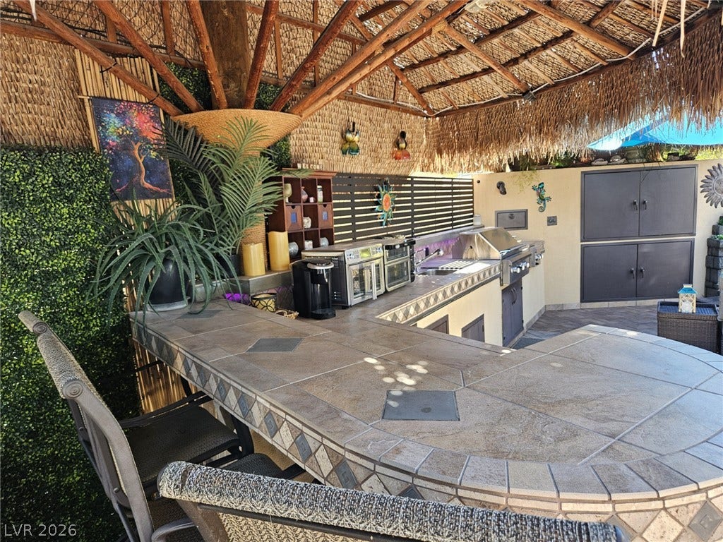 8175 Arville Street, #305, Las Vegas, NV 89139 Tiled counters and a thatched roof cover this fully equipped outdoor kitchen area.