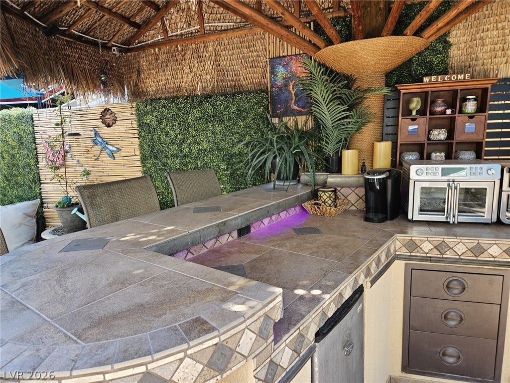 8175 Arville Street, #305, Las Vegas, NV 89139 An outdoor bar area features a tiled counter under a thatched roof structure.