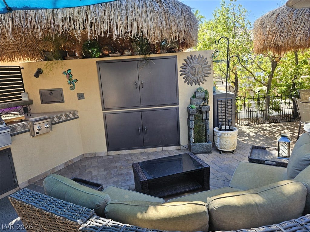 8175 Arville Street, #305, Las Vegas, NV 89139 An inviting outdoor kitchen area features paved tile flooring and a tropical thatched roof.
