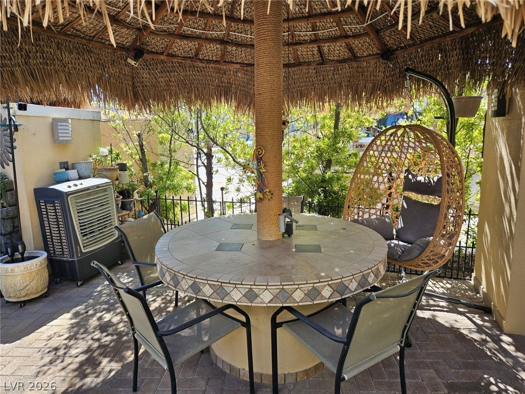 8175 Arville Street, #305, Las Vegas, NV 89139 A shaded tiki hut sits on a paved patio enclosed by classic wrought iron fencing.