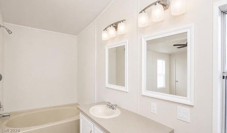 A spacious soaking tub sits adjacent to a classic double vanity with overhead lighting.