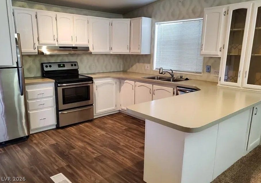 Gleaming wood-look floors anchor classic cabinetry and matching stainless steel appliances in this functional layout.