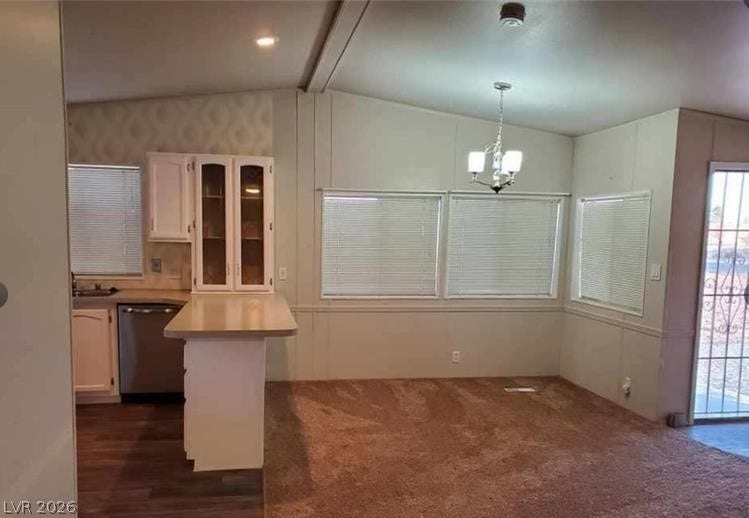 An open floor plan connects the carpeted living space to the adjacent kitchen area.