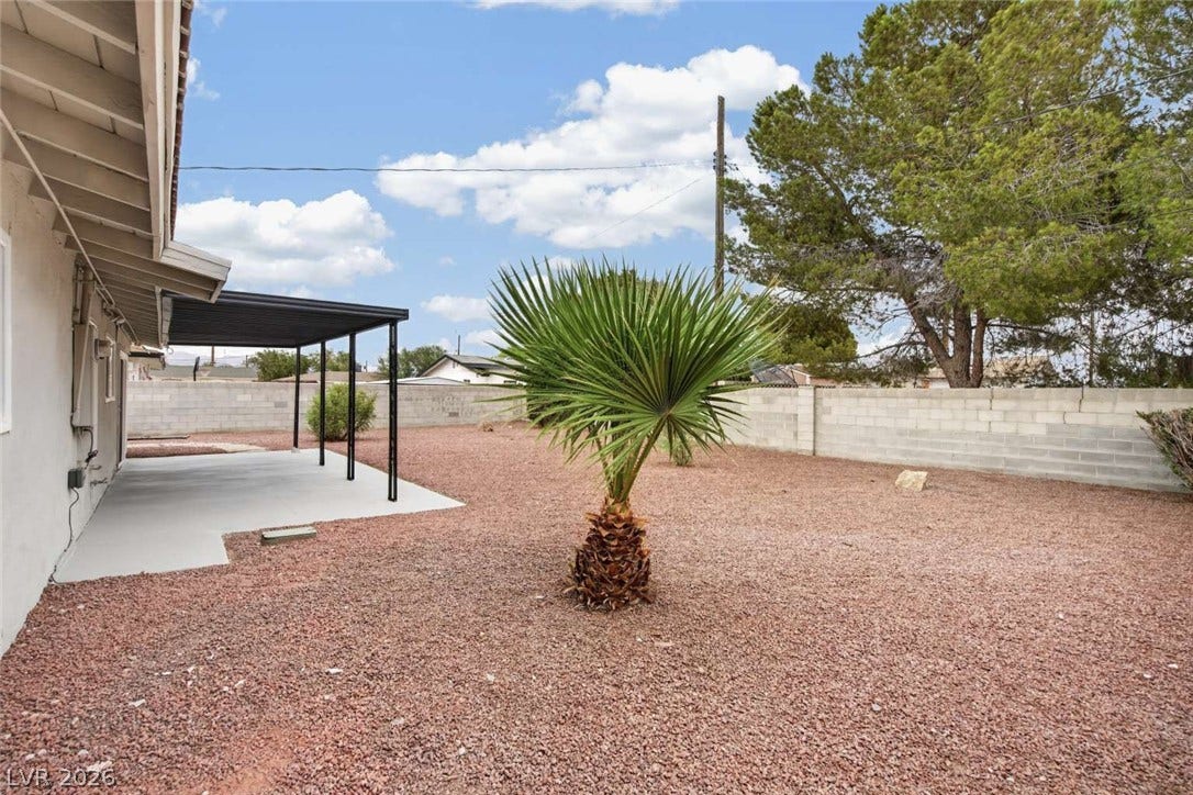 1669 N G Street, Las Vegas, NV 89106 An enclosed backyard features gravel landscaping, a concrete patio, and a block privacy wall.