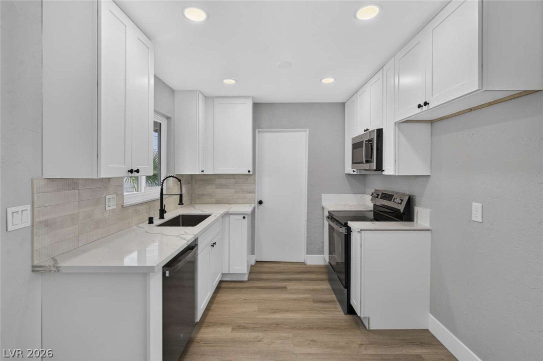 1669 N G Street, Las Vegas, NV 89106 Streamlined cabinetry and sleek countertops define this efficiently designed modern culinary space.