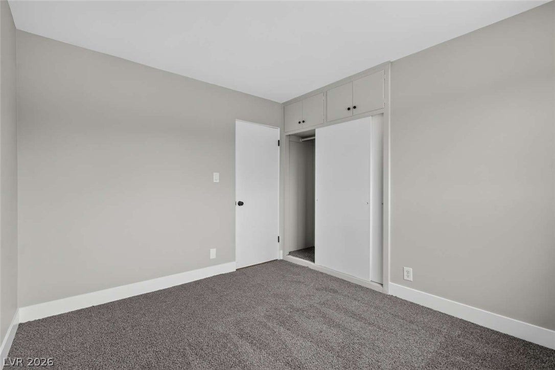 1669 N G Street, Las Vegas, NV 89106 Plush carpeting and built-in closet storage define this minimalist bedroom space.