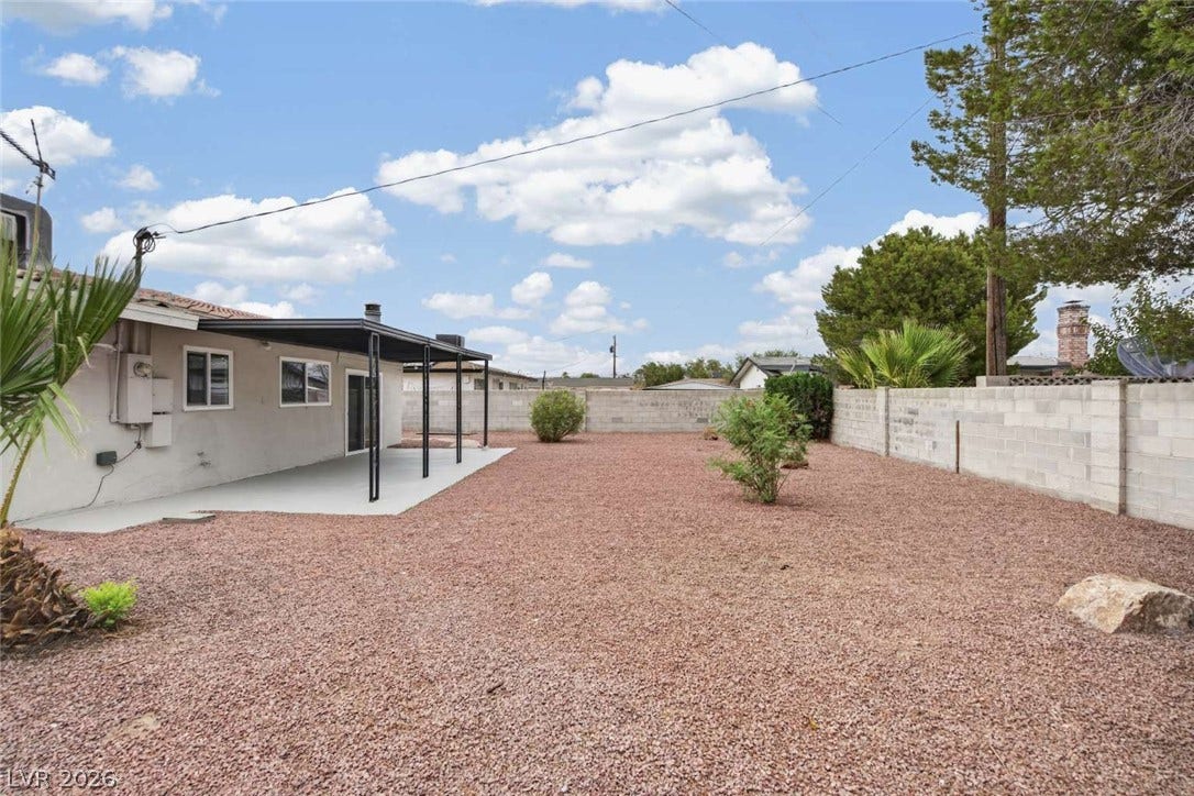 1669 N G Street, Las Vegas, NV 89106 An enclosed patio area transitions smoothly into a spacious, gravel-lined backyard space.