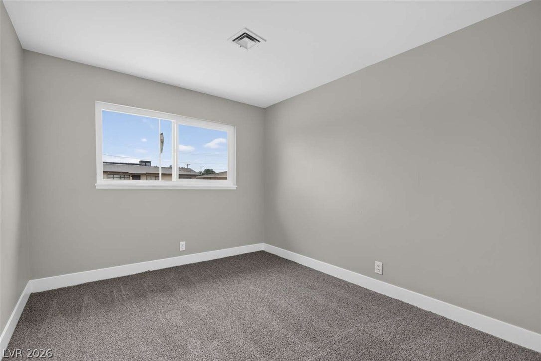 1669 N G Street, Las Vegas, NV 89106 A well-placed window frames neighborhood views in this comfortable bedroom with soft carpeting.