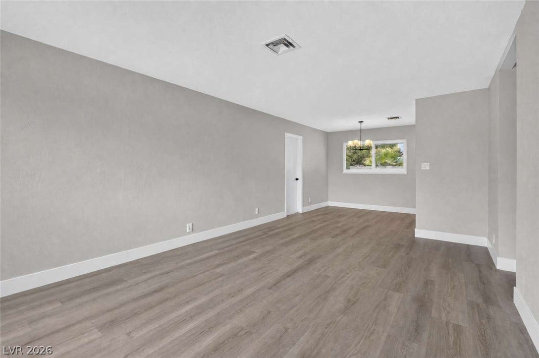 1669 N G Street, Las Vegas, NV 89106 Smooth wood-style flooring and minimalist plaster-finish walls define this airy, open space.