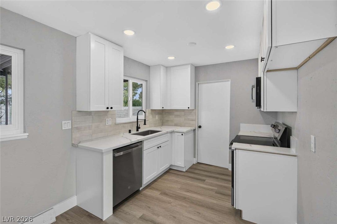 1669 N G Street, Las Vegas, NV 89106 Recessed lighting illuminates this updated kitchen featuring durable wood-look flooring and solid countertops.